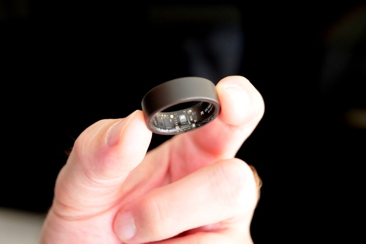 A person holding the Ultrahuman Air ring, showing the sensors.
