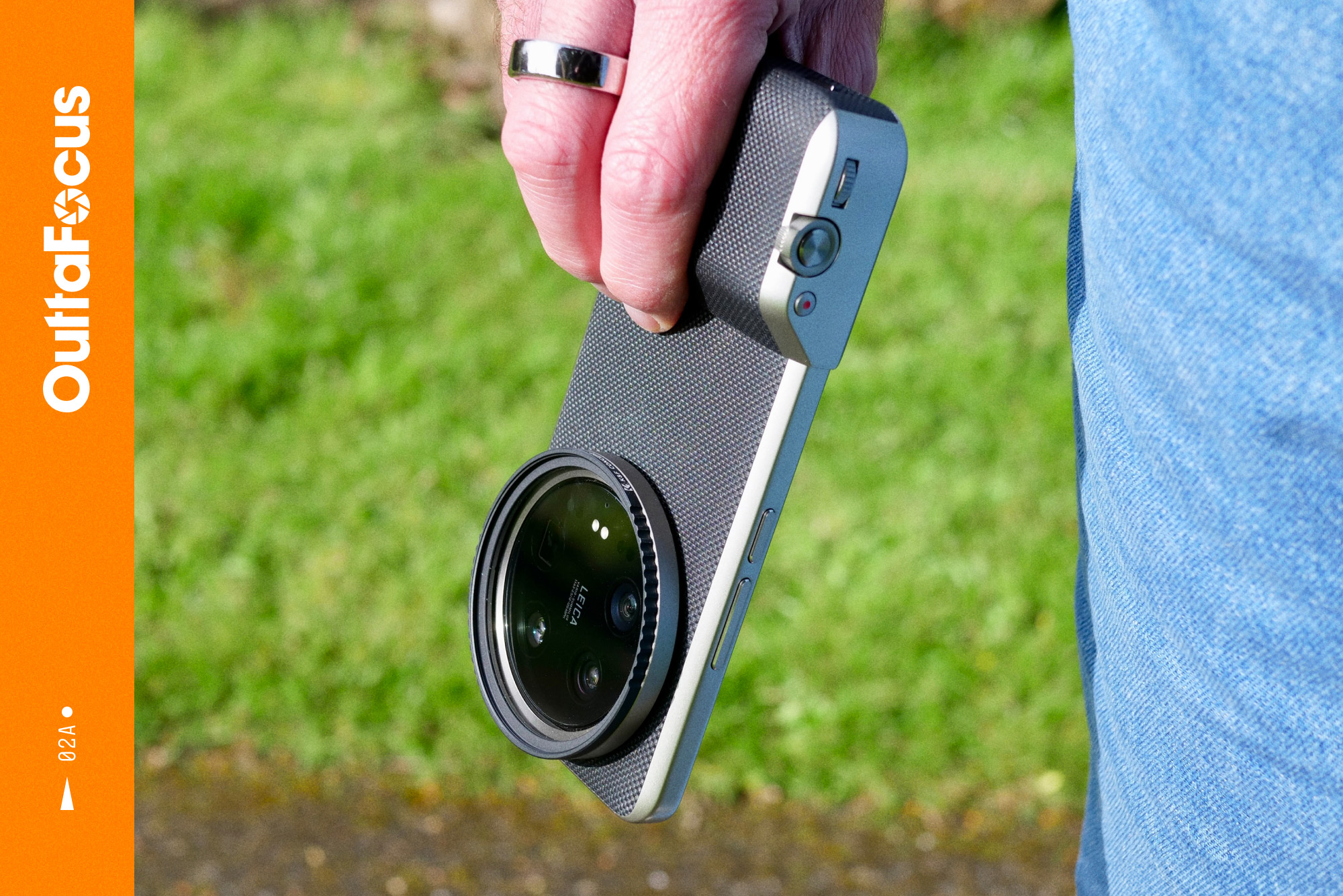 Promotional image for OuttaFocus. A person holding the Xiaomi 14 Ultra, with the Photography Kit fitted.