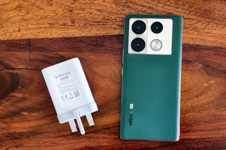 Infinix Note 40 Pro+ with green vegan leather back and a 100W charger kept on the side.