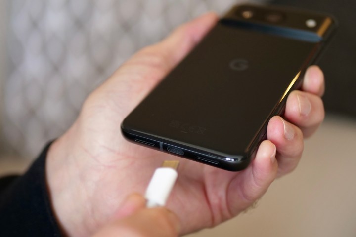 A person putting the Google Pixel 8 on charge.