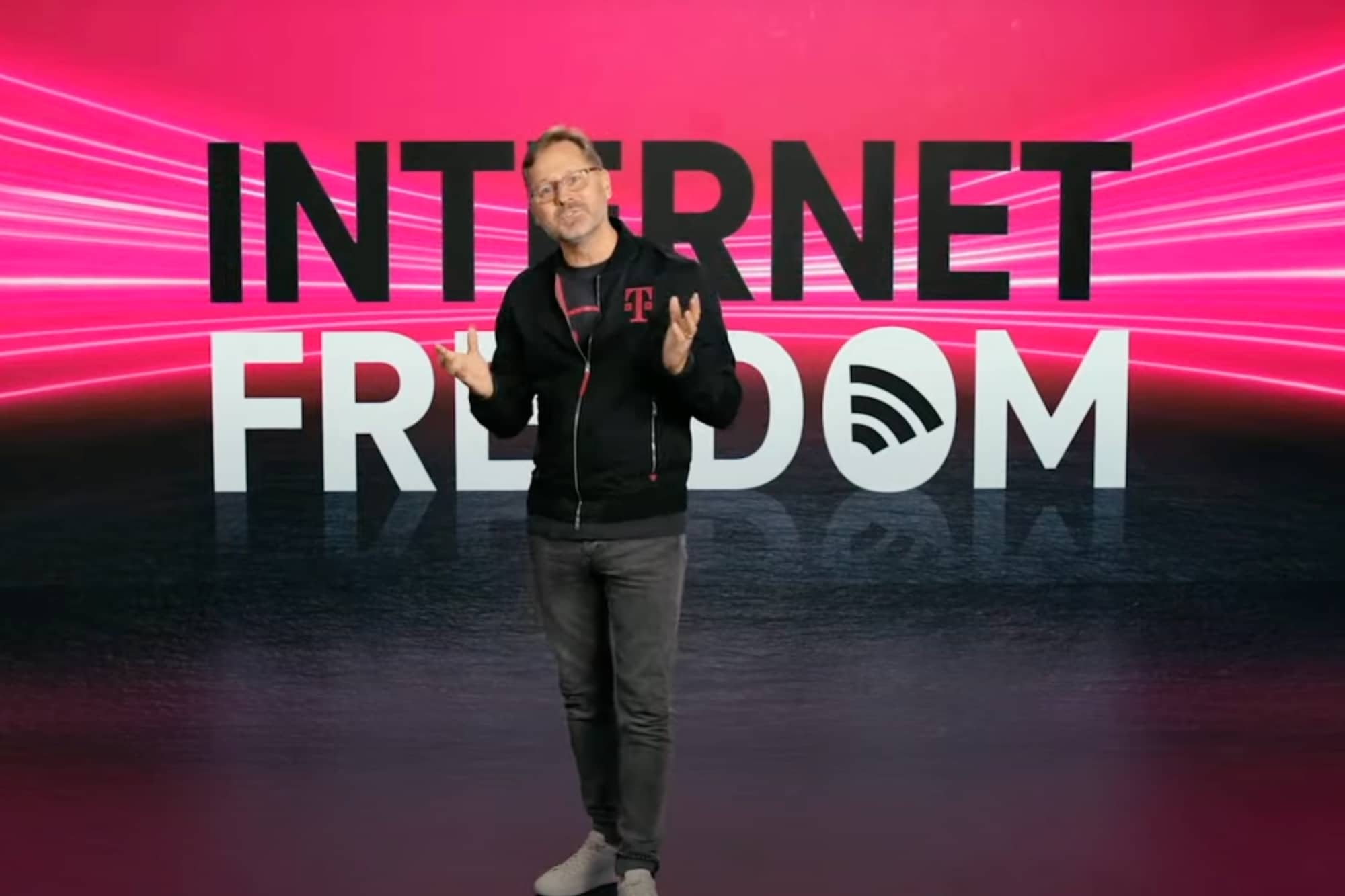 T-Mobile CEO Mike Sievert standing in front of a banner that reads Internet Freedom.