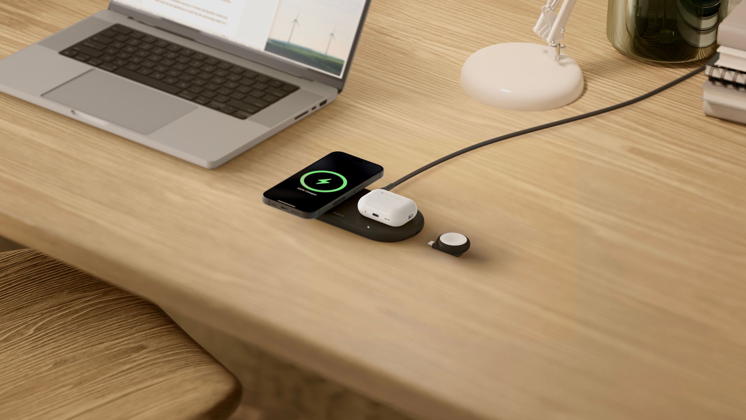 A Belkin wireless charging pad on a wooden desk.